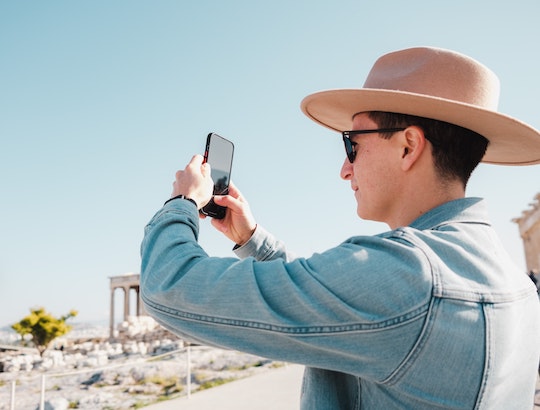 man vlogging on vacation with iphone